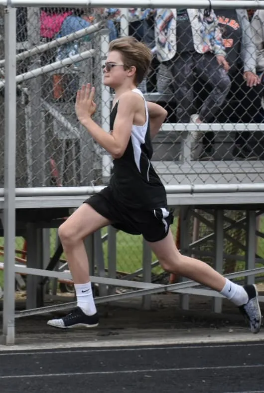 Young track athlete sprinting at full speed